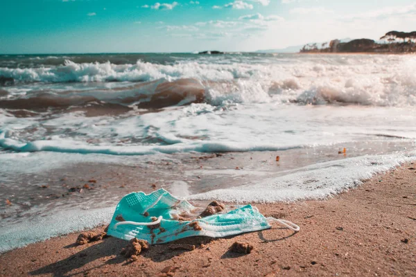 Surgical face mask abandoned on a beach — Stock Photo, Image