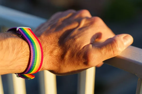 Vista de cerca de una mano de hombre con una pulsera de arco iris LGBT. — Foto de Stock
