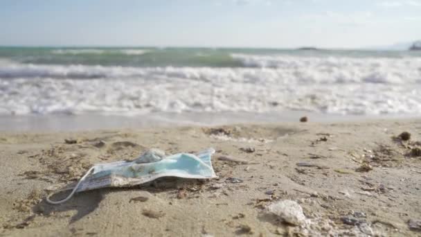 Masque chirurgical abandonné sur une plage — Video