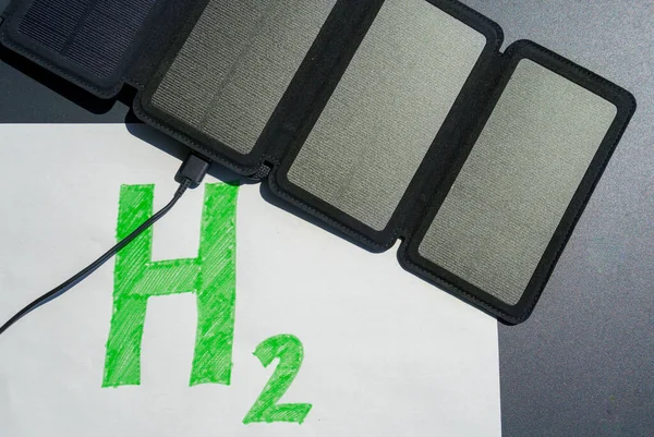 Idrogeno verde. Pannello solare collegato al testo H2, che simboleggia la generazione di idrogeno da energia solare senza combustibili fossili. — Foto Stock