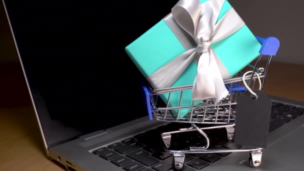 Kleiner Warenkorb mit einem Geschenk im Inneren und einem schwarzen Anhänger — Stockvideo