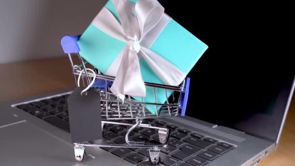 Small shopping cart with a gift inside and a Black tag — Stock Video