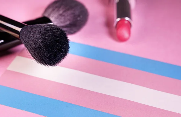 Szminka i pędzle do makijażu z bliska widok na flagę transgender — Zdjęcie stockowe