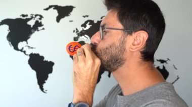 Bir dolar sembolü ve arka planda bir dünya haritası olan bir balonu şişiren adam. Ekonomik enflasyon yükseliş konsepti