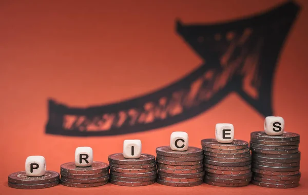 Montones de monedas con los precios de la palabra en el fondo con flecha roja — Foto de Stock