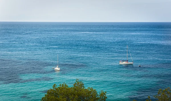 Dvě plující lodi na modré středomořské vody v Ibiza island — Stock fotografie