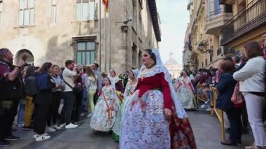 Valencia, İspanya. 18 Mart 2024, süslü Fallera kostümlü kadınlar ve kızlar renkli UNESCO Fallas Festivali sırasında kalabalık Valencia sokaklarında geçit töreni yapıyorlar.