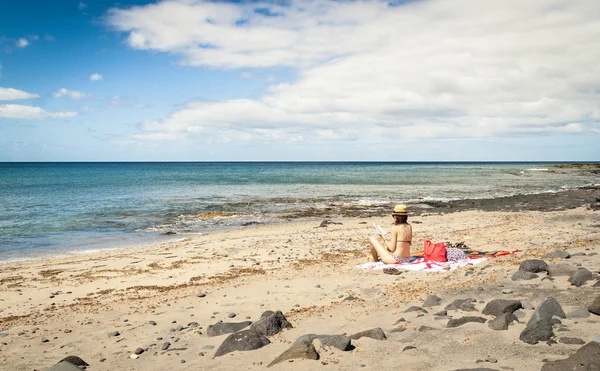 Bikini dziewczynka czytania książki w relaks nastroju w wyspa samotna beach Fuerteventura — Zdjęcie stockowe