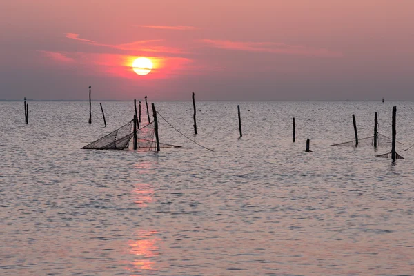 Solnedgång över nederländska havet med fisknät — Stockfoto