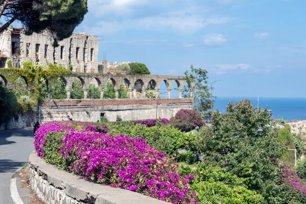 花と、イタリアのシチリア島のタオルミーナの古代建築 — ストック写真