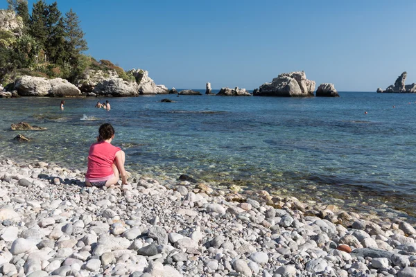 Одинокий турист делает телефонный звонок на пляже Сицилии, Италия — стоковое фото