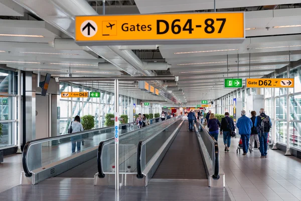 Reizigers wandelen naar de gate op Schiphol, Nederland — Stockfoto