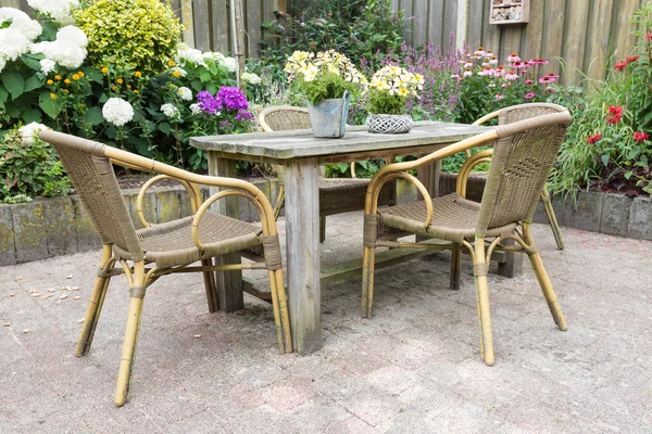 Wooden table and chairs in a ornamental garden — Stock Photo, Image