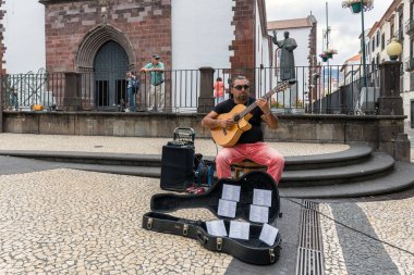 Busker, Portekiz 'in Madeira Adası' nda gitar çalıyor.