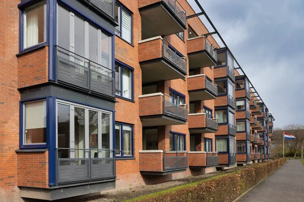 Mehrstöckiges Mehrfamilienhaus aus roten Ziegeln und Balkon — Stockfoto