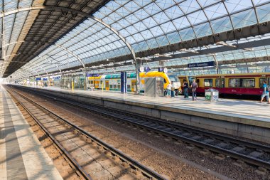 Almanya 'nın Spandau tren istasyonunda gezginler ve yolcular bekliyor.