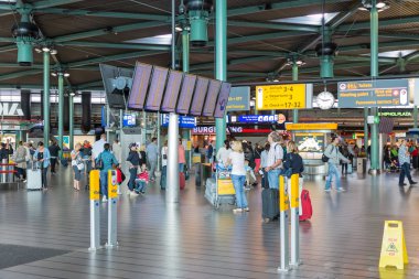 schiphol Havaalanı'na seyahat edenler, bilgi panelleri ve mağazalar ile Merkez Binası