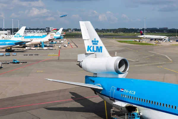 Schiphol airport with workers and departing and arriving airplanes — Stock Photo, Image