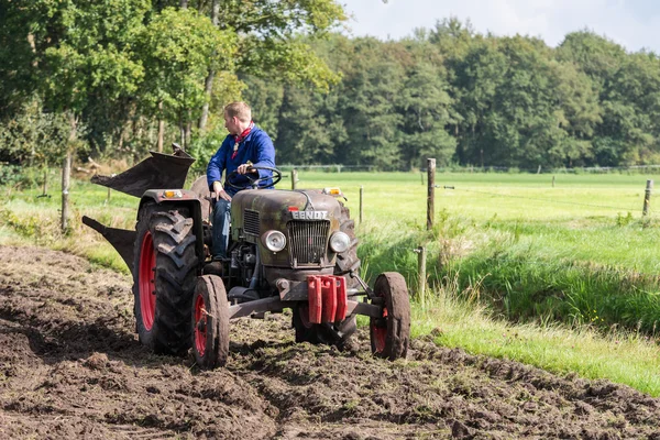 Farmer riding with an old tractor during a Dutch agricultural festival — Stock Photo, Image