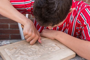 Bboy Urk geleneksel giysiler içinde bir ahşap carvin yapıyor