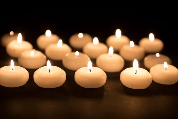 Diverse candele bianche con messa a fuoco selettiva su sfondo nero — Foto Stock