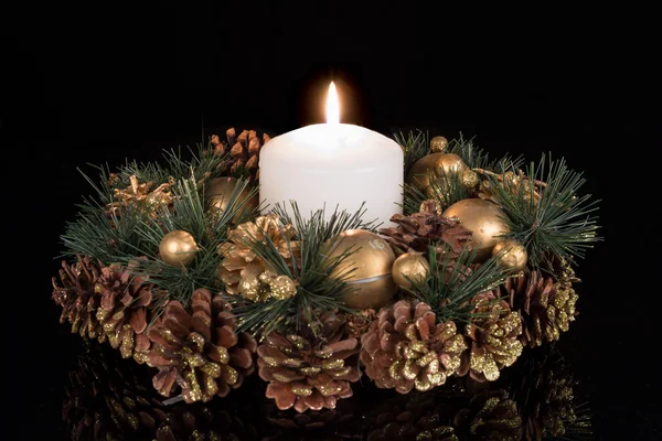 Decoración de Navidad con una vela blanca y manzanas de pino en un fondo negro —  Fotos de Stock