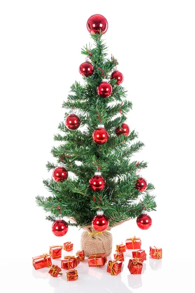 Різдвяна ялинка з червоними кульками та подарунками ізольовані на білому — стокове фото