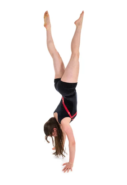 Молодая женщина стоит на руках во время гимнастических упражнений. изолированный над белым — стоковое фото