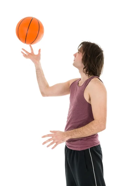 Young man with spinning basketball at his forefinger — Stock Photo, Image