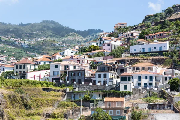 Dorpje bouwen tegen een berghelling op het eiland Madeira — Stockfoto