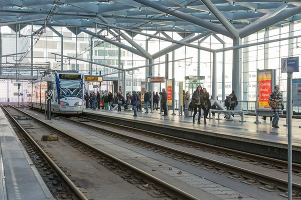 Menschen, die mit der Straßenbahn am Hauptbahnhof von Den Haag, den Niederlanden — Stockfoto