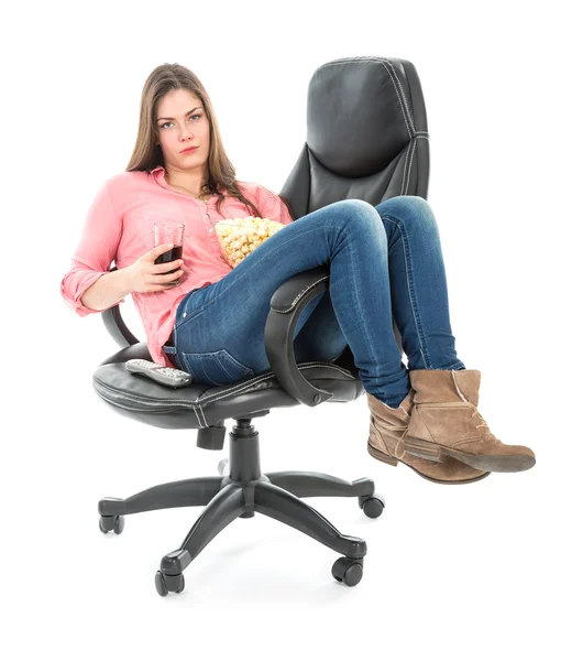 Ледача жінка сидить розтягнута в кріслі з попкорном і випивкою — стокове фото
