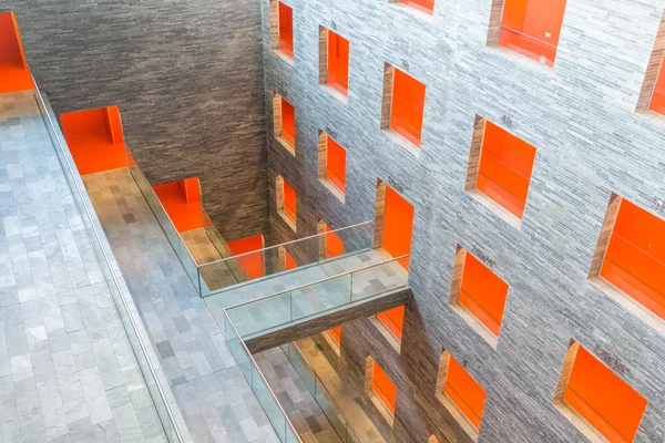 Interieur modern gebouw met meerdere verdiepingen en oranje geschilderd passages Stockfoto