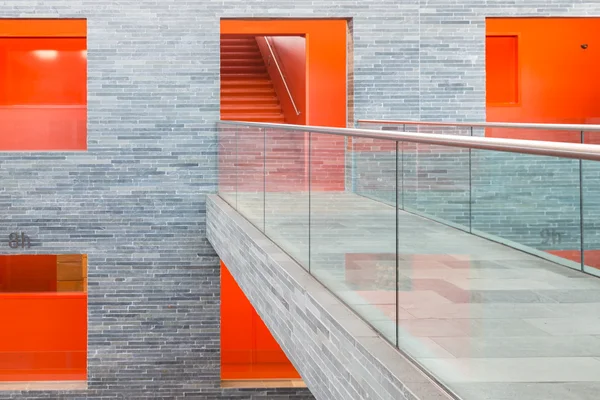 Edifício moderno de passarela com vários andares e passagens pintadas de laranja Fotos De Bancos De Imagens