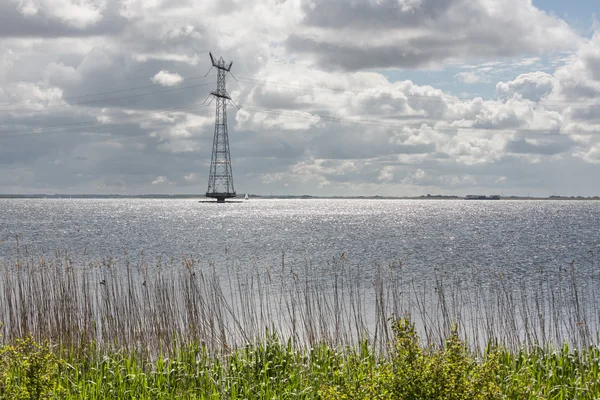 电力塔在荷兰湖与许多的太阳反射 — 图库照片