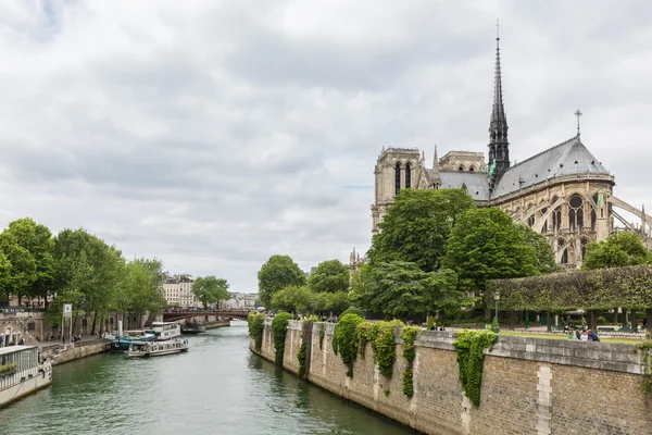 Turister runt katedralen Notre Dame längs floden Seine i Paris — Stockfoto