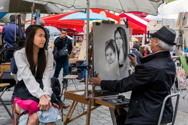 Artista callejera está pintando a una mujer en Montmartre, París — Foto de Stock