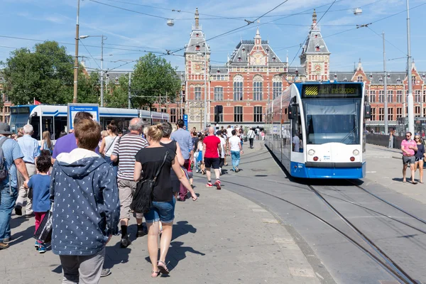 Touristen zu Fuß in der Nähe einer Straßenbahn in Amsterdam — Stockfoto