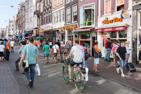 Toeristen in Amsterdam winkelen en op zoek naar een restaurant — Stockfoto