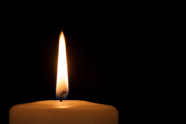 Burning candle in the dark with copy space