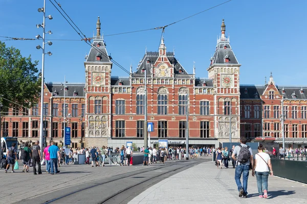 Toeristen lopen tegenover het centraal station van Amsterdam — Stockfoto