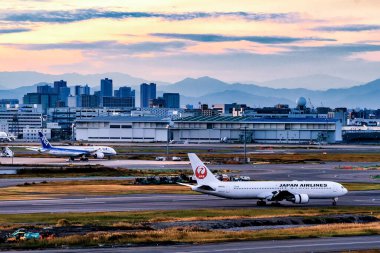 Japonya - 19 Kasım 2019: Japon havayolları ve ANA uçakları Tokyo Haneda Uluslararası Havaalanı, Tokyo Havaalanı 'nın arka planında taksicilik yapıyor.
