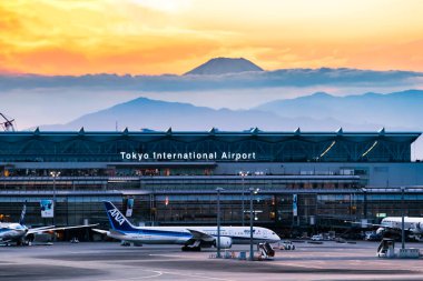 Japonya - 19 Kasım 2020: Tokyo Haneda Uluslararası Havalimanı pistlerinde taksicilik yapan ANA uçağı, Fuji dağı arka planında gün batımında, Tokyo