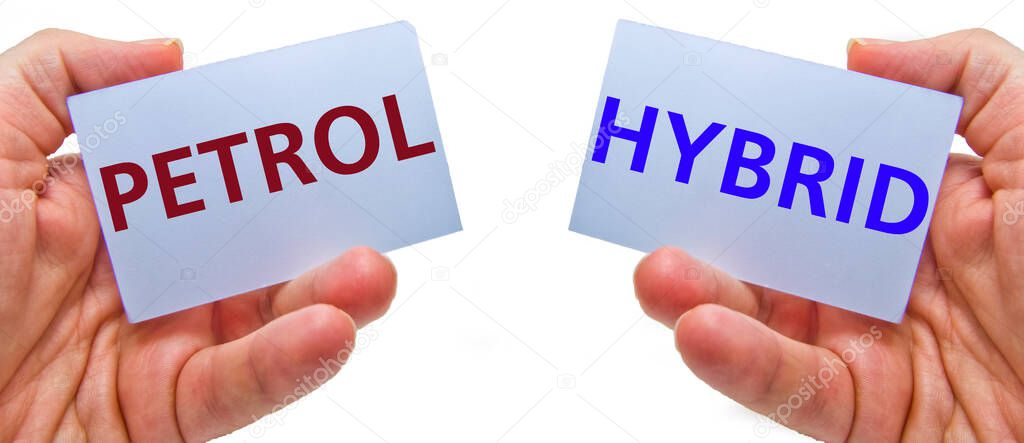 man hands holding cardstocks with the words hybrid and petrol. Concept for ecology, renewable industry, global warming, green tax, green transportation