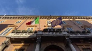 Hükümet binasının balkonunda rüzgarda sallanan İtalyan ve Avrupa bayrakları. Turizm, vatanseverlik, uluslararası ticaret, politika, ticaret konsepti