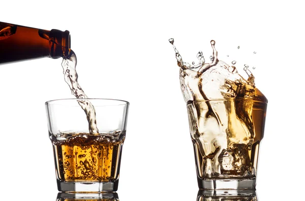 Pouring whiskey in a clear glass, on white background — Stock Photo, Image