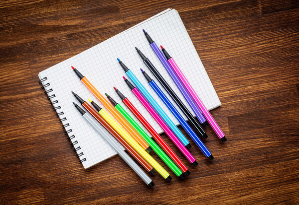 Copyspace blank sheet of white paper covered with multiple colorful felt pen markers