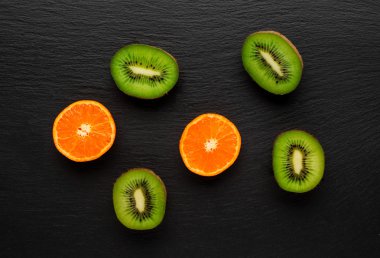 kivi ve mandarin karanlık taş zemin üzerine.