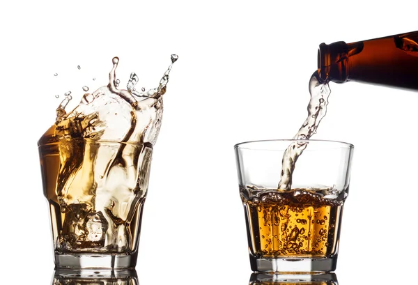Beyaz arka plan üzerine açık bir bardak viski dökme — Stok fotoğraf