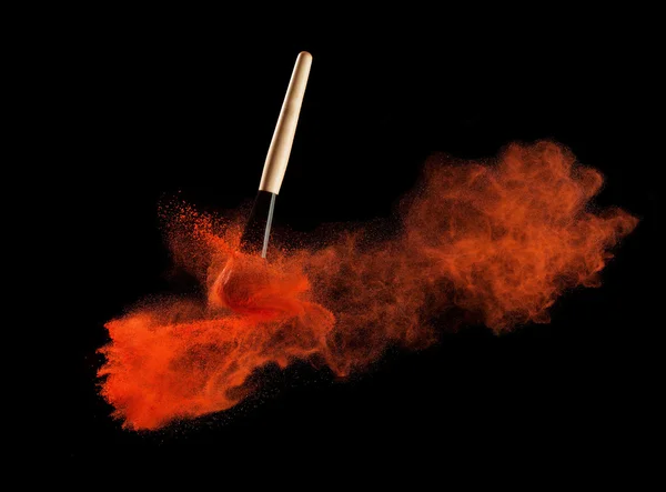 Cepillo de maquillaje con redpowder explosión en fondo negro — Foto de Stock